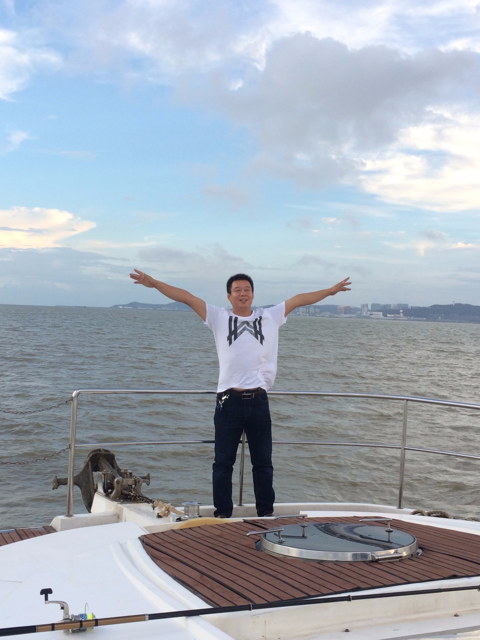 垂钓的帅哥,钓鱼没了耐心,索性在船头玩起了泰坦尼克号的经典动作--"